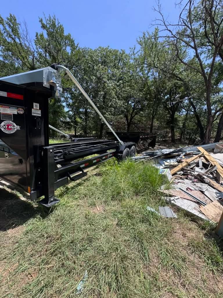 Dumpster trailer loading construction debris at a rural Johnson County jobsite